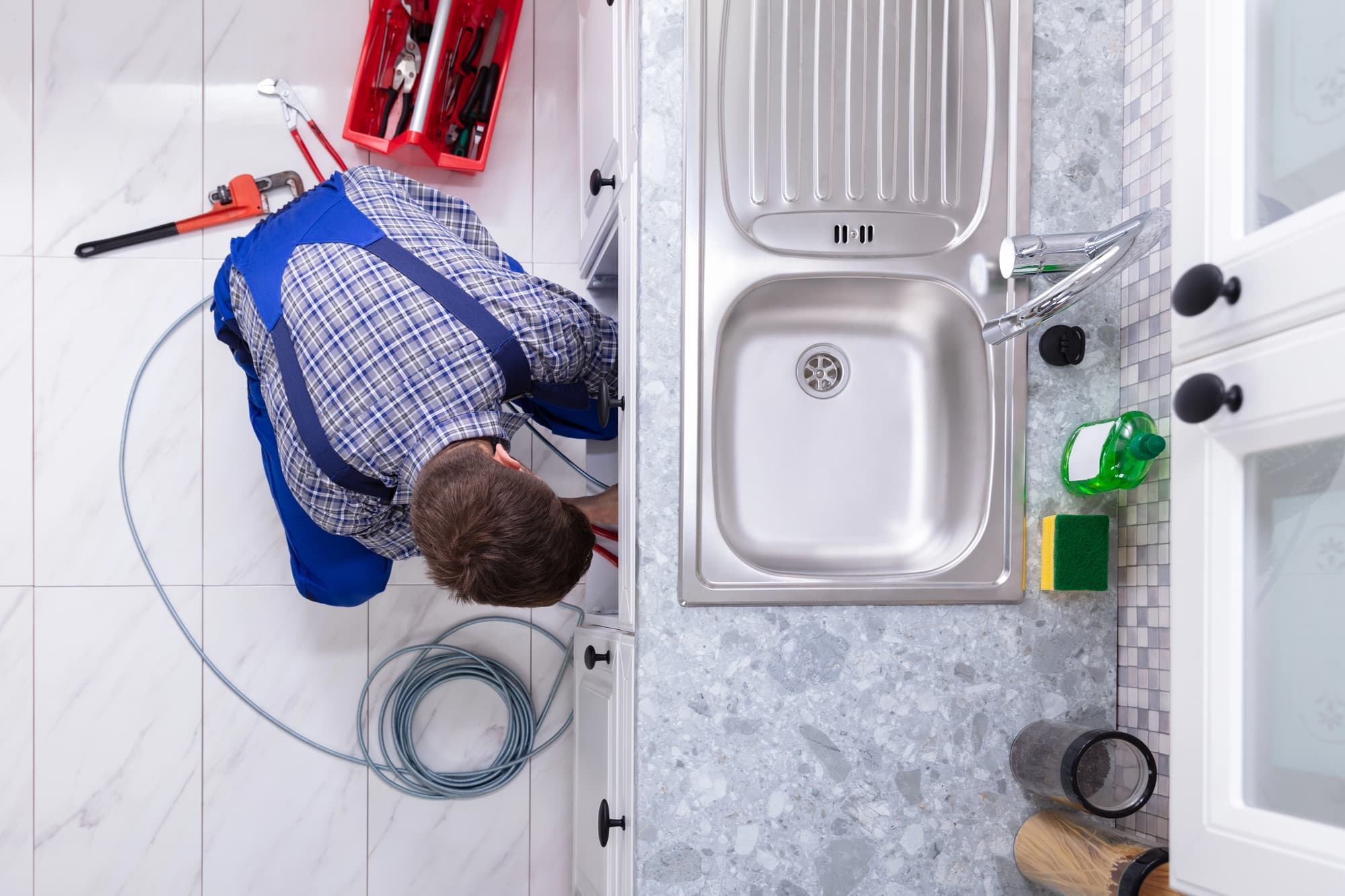 Plumber cleaning a drain in a Chilliwack residential property.